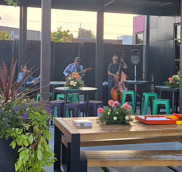 band playing outside at venue with flowers and stools