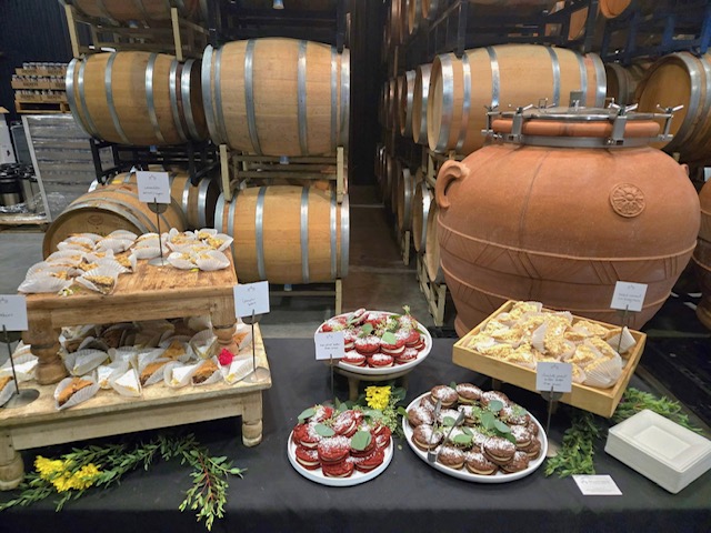 cheese and snacks with barrels of wine in the background